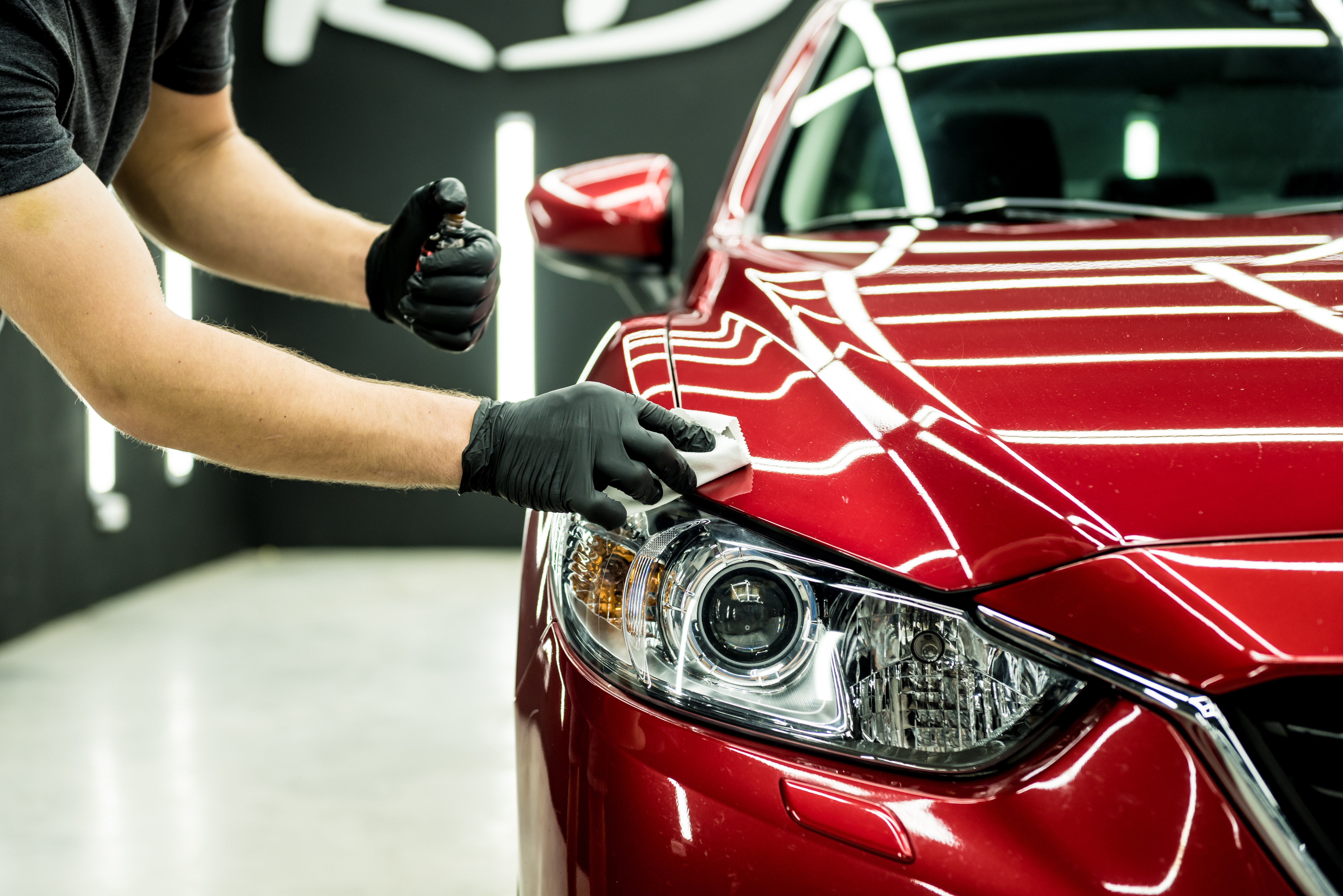 Car service worker applying nano coating on a car detail