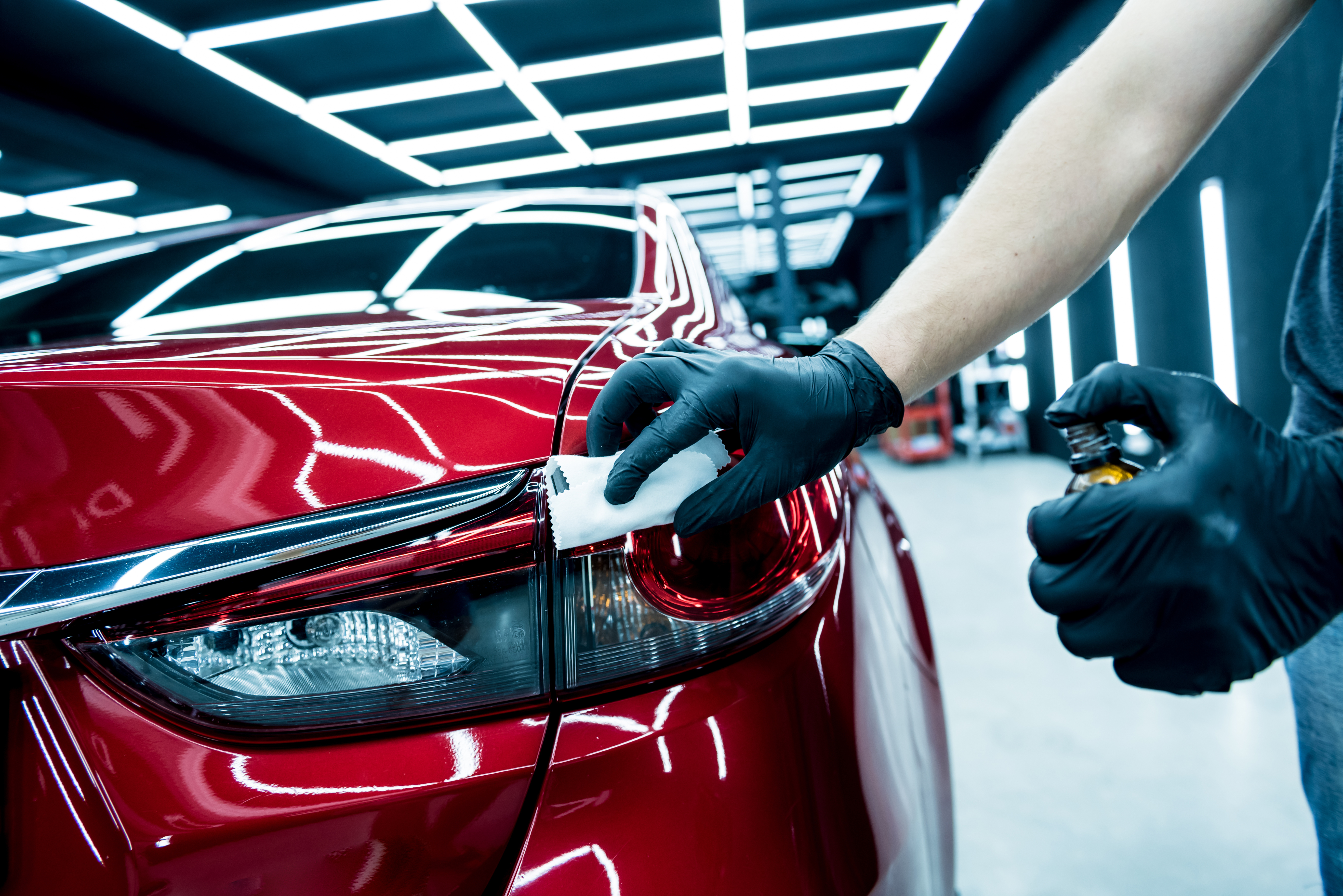 Car service worker applying nano coating on a car detail